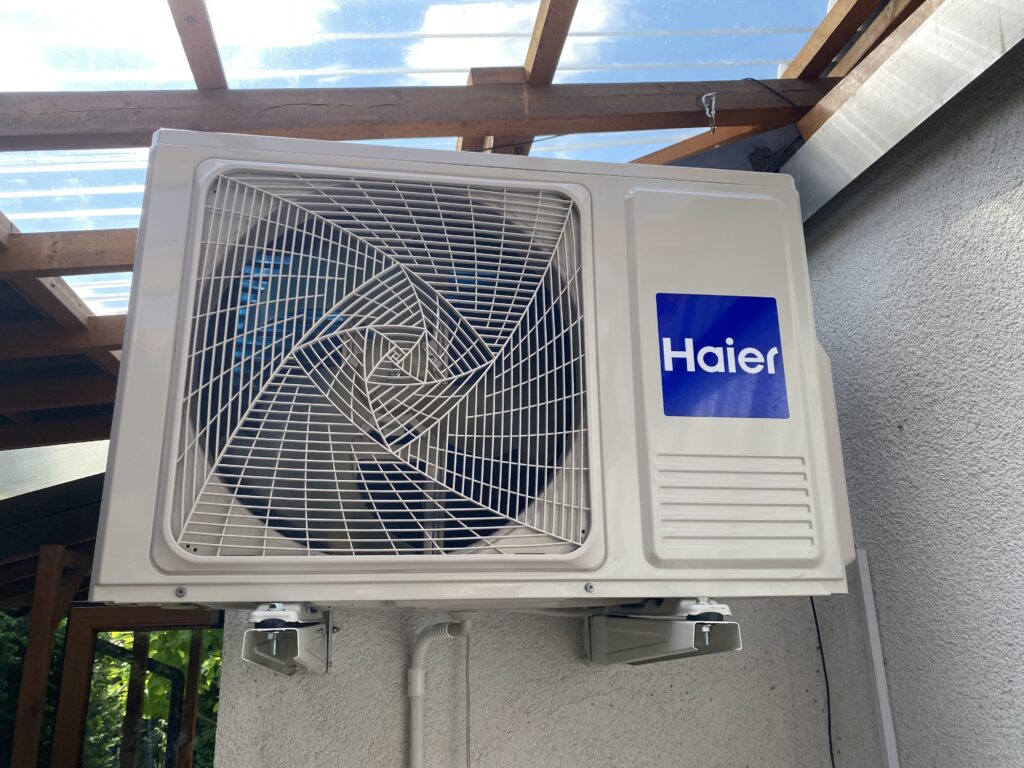 Jednostka zewnętrzna klimatyzacji Haier zamontowana na elewacji domku na ogródkach działkowych